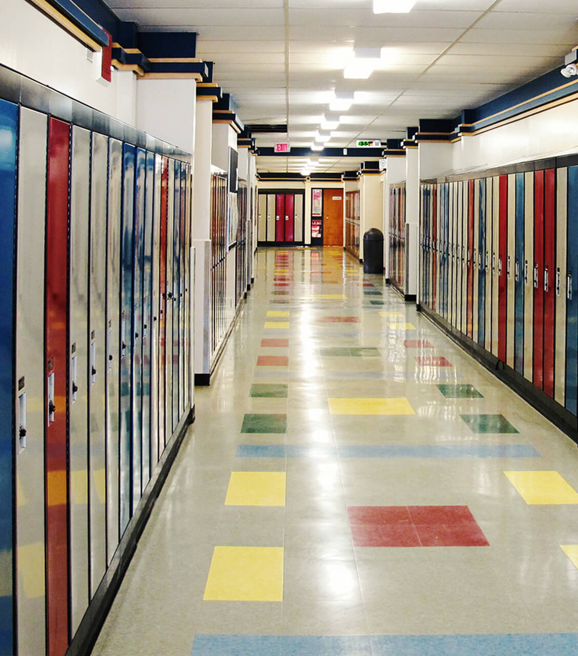 Pasillo con taquillas grises, rojas y azules, en instituto americano