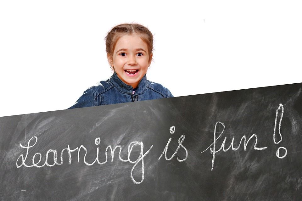 niña con cartel de learning is fun